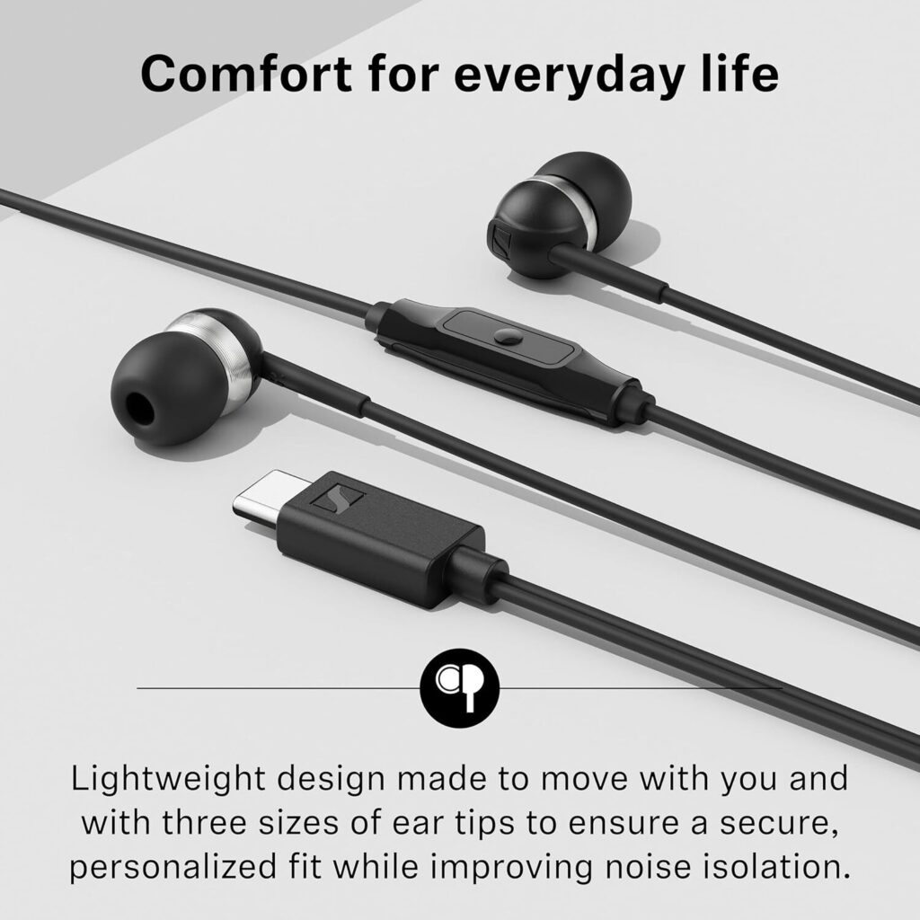 A high-angle studio product shot of the black Sennheiser CX 80U earbuds resting on a light grey surface. The image highlights the USB-C connector, the ultra-compact earbud housings with silver metallic accents, and the in-line one-button remote. Text at the top reads "Comfort for everyday life," while the bottom text notes the lightweight design and the inclusion of three sizes of ear tips for a personalized fit and improved noise isolation.